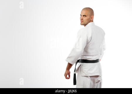 Junge sportliche Mann im weißen Kimono für sambo, Judo, Jujitsu auf weißem Hintergrund posiert, steht mit zurück Stockfoto