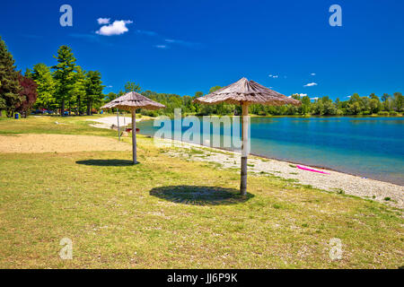Strand und Sonnenschirme am Soderica See, Podravina Region in Kroatien Stockfoto
