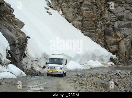 Ladakh, Indien - 18. Juli 2015. Ein Tourist Auto läuft auf gefährliche Bergstraße mit Schnee in Leh, Ladakh, Indien. Ladakh ist das höchste Plateau in die stat Stockfoto