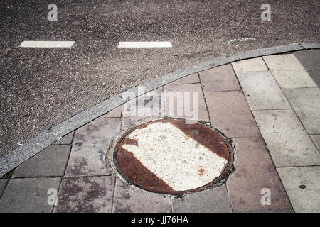 rostige Kanalisation Luke in der Nähe der Straße. Urban, Hintergrund. Stockfoto