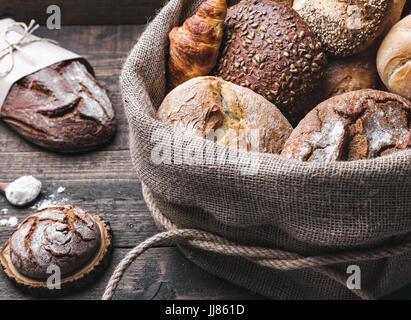 Lecker, frisch gebackenes Brot in meschotschek auf hölzernen Hintergrund Stockfoto