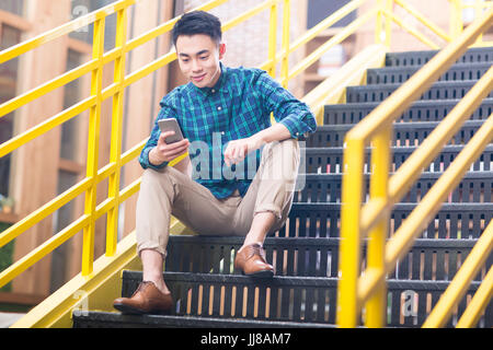 Junger Mann mit Handy Stockfoto