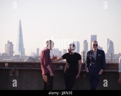 London, UK - 12. Juni 2015: Menschen entspannen bei einem Drink an einer bar mit Blick auf die Skyline von London an einem sonnigen Abend auf dem Dach Stockfoto