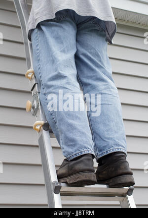 Mann auf der Leiter mit Haus Abstellgleis Hintergrund Stockfoto