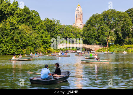 New Yorker Central Park, Boot rudern an einem sonnigen Tag, Bogenbrücke auf der Rückseite Stockfoto