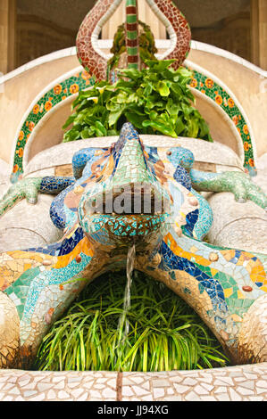 Bunte Statue von Lizard mit schönen waren im Glas mit fließendem Wasser und Pflanzen um in den Park Güell, Barcelona, Spanien Stockfoto