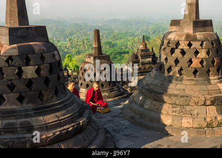 Rot gekleideten Mönche beten bei Sonnenaufgang am Weltkulturerbe Borobudur buddhistischen Tempel. Stockfoto