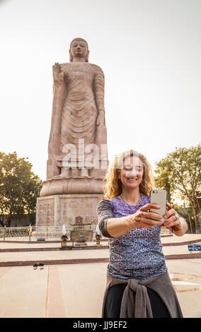 Eine Frau, die ein Selbstportrait von sich selbst vor Thai Buddha Vihar in Sarnath, Indien. Stockfoto