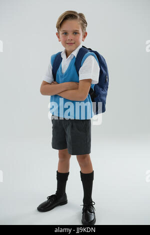 Porträt von niedlichen Schüler stehen mit verschränkten vor weißem Hintergrund Stockfoto
