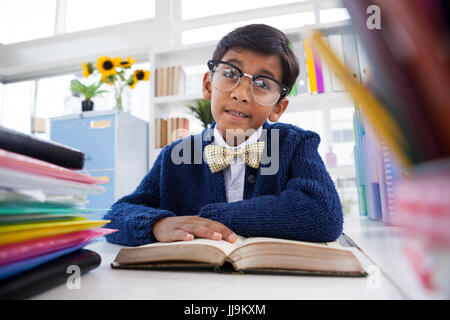 Porträt des Geschäftsmannes tragen Brillen beim Sitzen am Schreibtisch im Büro Stockfoto