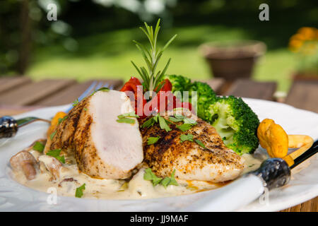 Gegrilltes Hähnchen, Sahne-Sauce mit Champignons Pfifferlingen, Brokkoli und geröstete Paprika. Gesunde ausgewogene Ernährung Konzept. Stockfoto