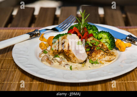 Gegrilltes Hähnchen, Sahne-Sauce mit Champignons Pfifferlingen, Brokkoli und geröstete Paprika. Gesunde ausgewogene Ernährung Konzept. Stockfoto