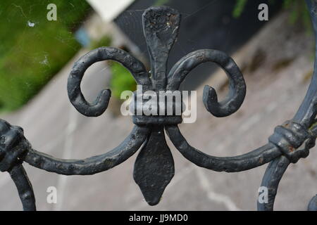 Fleur de Lis lys Nahaufnahme Detail von Verwitterten schwarz lackiert dekorative Metal Gate re Architektur Design schmiedeeiserne Arbeit Erbe Stockfoto