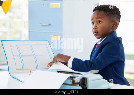 Geschäftsmann während der Arbeit am Schreibtisch im Büro wegschauen Stockfoto