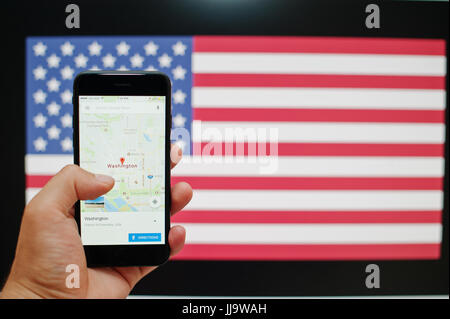 Kiew, Ukraine - Jul 11,2017: Apple iPhone 7 mit Google-Maps-Anwendung zeigt Washington auf dem Bildschirm zur hand Hintergrund USA-Flagge. Stockfoto