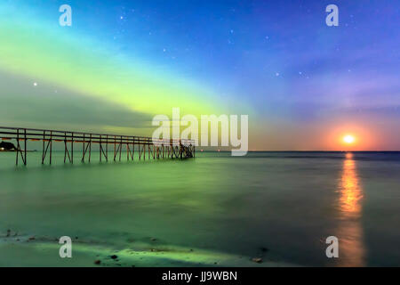 Aurora Borealis oder das Nordlicht mit zunehmender Mond über Lake Winnipeg, Manitoba, Kanada. Stockfoto