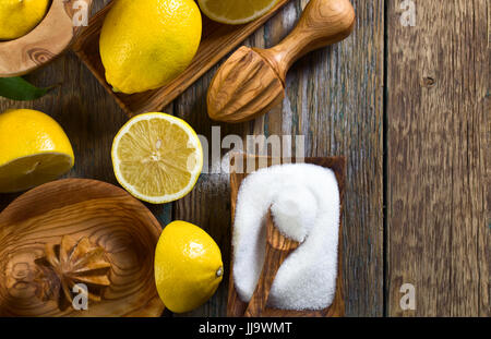 Reife Zitronen und Saftpresse auf einem alten Holztisch. Ansicht von oben. Kopieren Sie Raum. Stockfoto