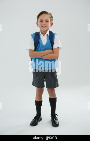 Porträt von niedlichen Schüler stehen mit verschränkten vor weißem Hintergrund Stockfoto