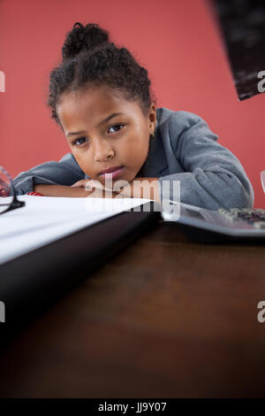 Porträt der Geschäftsfrau stützte sich auf Schreibtisch gegen hautnah Stockfoto