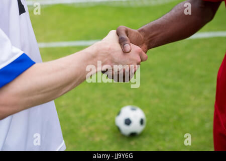 Zugeschnittenes Bild des Fußballspielers Handshake auf Spielfeld stehend zu tun Stockfoto