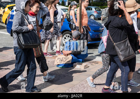 Obdachloser auf Bürgersteig sitzend mit "Bitte helfen Sie" Zeichen bitten um Geld, Vancouver, BC. Stockfoto