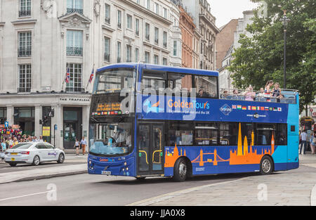 Offene Spitze Doppel Decker Golden Tours Sightseeing Bus Kurven nahe Trafalgar Square (aus Bild) vor The Trafalgar Hotel, central London, Stockfoto