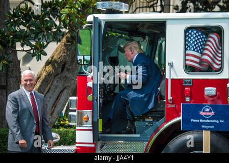 Washington, Vereinigte Staaten von Amerika. 17. Juli 2017. US Präsident Donald Trump sitzt hinter dem Lenkrad ein Feuerwehrauto Pierce als Vizepräsident Mike Pence während Made in Amerika Product Showcase auf dem South Lawn des weißen Hauses 17. Juli 2017 in Washington, DC zusieht. Bildnachweis: Planetpix/Alamy Live-Nachrichten Stockfoto