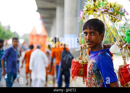 Ghaziabad, Indien. 19. Juli 2017. Kavad Yatra ist eine beliebte jährliche Wallfahrt der Anhänger von Shiva während der Monsunzeit. Pilger Personenbeförderung überdachte Wasser-Potsor "Kānvars" über ihre Schultern geschlungen. Diese Töpfe tragen das heilige Wasser vom Fluss Gan Credit: Anil Ghawana/Alamy Live News Stockfoto