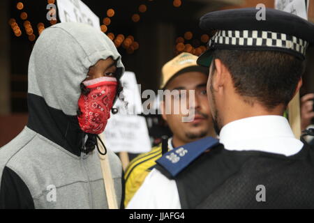 London, UK. 19. Juli 2017. Ein Polizist steht ein paar jungen Demonstranten.  Proteste stattfinden außerhalb der Kensington und Chelsea Rat Gebäude wie der Rat trifft die Grenfell Katastrophe diskutieren einen Monat, nachdem es passiert ist. Roland Ravenhill/Alamy Live-Nachrichten. Bildnachweis: Roland Ravenhill/Alamy Live-Nachrichten Stockfoto