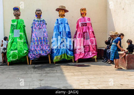 Parramos, Guatemala - 29. Mai 2016: Einheimische warten außerhalb der Kirche während der Corpus Christi Masse neben bunten Riesen Volkstänzer Marionetten namens Gigantes Stockfoto