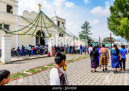 Parramos, Guatemala - 29. Mai 2016: Traditionell gekleidete Maya Frauen tragen Kreuze für Fronleichnamsprozession außerhalb der Kirche während der Messe. Stockfoto