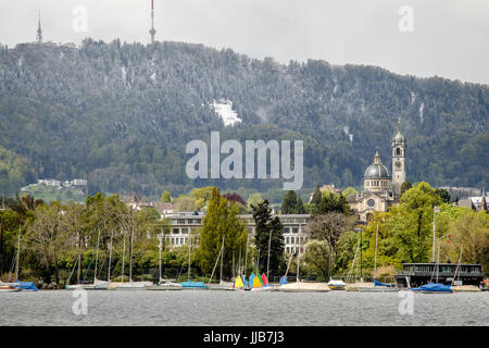 Schnee fällt und Sonne scheint vom Ostufer des Zürichsees mit Uetliberg im Hintergrund nach Westen Stockfoto