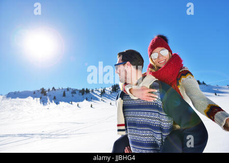 Liebespaar im Schnee draußen zusammen zu spielen. Stockfoto