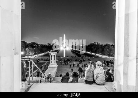 Leute sitzen auf den Stufen des Lincoln Memorial in Washington und Blick über reflektierende Pool - WASHINGTON DC - COLUMBIA - 9. April 2017 Stockfoto