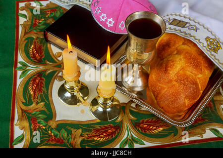 Schabbat-Kerzen im Glas-Leuchter mit unscharfen überdachte Challah Hintergrund. Stockfoto