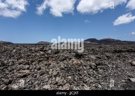 Schwarze Lavafeld in der bizarren Vulkanlandschaft des Timanfaya National Park an einem sonnigen Tag. Lanzarote, Kanarische Inseln, Spanien Stockfoto