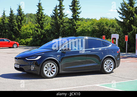 PAIMIO, Finnland - 14. Juli 2017: Tesla Model X-Elektro-Fahrzeug verläßt Tesla Kompressor-Station. Das Modell X ist ein elektrischer Luxus Crossover SUV Mann Stockfoto