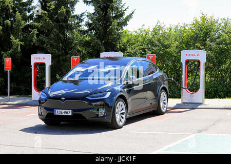 PAIMIO, Finnland - 14. Juli 2017: Tesla Model X Elektro-Auto wird an Tesla Kompressor-Station geladen. Das Modell X ist ein elektrischer Luxus crossove Stockfoto