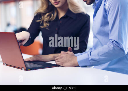 Junges Paar auf einem Laptop im Büro zusammenarbeiten. Teamarbeit-Konzepte. Stockfoto