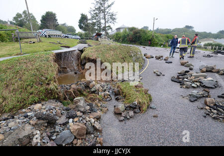 Notdienste-Umfrage die Schäden an einer Straße in Coverack, Cornwall, nach intensivem Regen verursachte Sturzfluten in dem Dorf an der Küste. Stockfoto