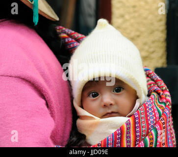 PUNO, PERU - Februar 10: Traditionelle Art und Weise des Tragens der kleinen Kinder in Südamerika auf Straßen Puno Stadt im 10. Februar 2012 Stockfoto