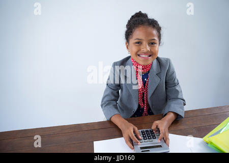 Porträt von glücklichen Mädchen vorgibt als Geschäftsfrau mit Rechner während der Arbeit am Schreibtisch Stockfoto