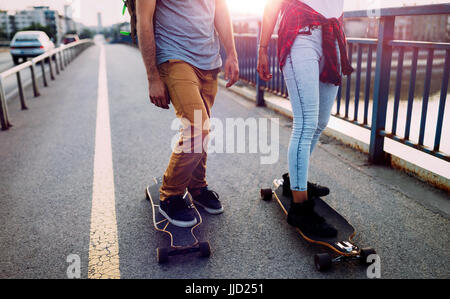 Junges attraktives Paar Skateboard fahren und Spaß haben Stockfoto