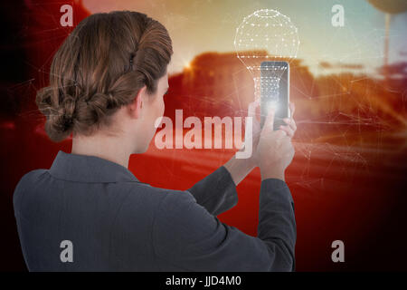 Geschäftsfrau mit Handy gegen Licht Routen auf Stadtstraße Stockfoto