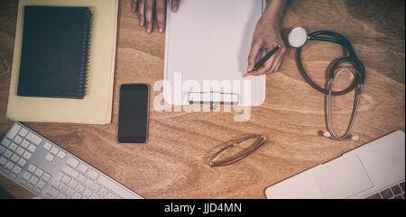 Draufsicht der Arzt schreiben auf Zwischenablage am Schreibtisch im Krankenhaus Stockfoto