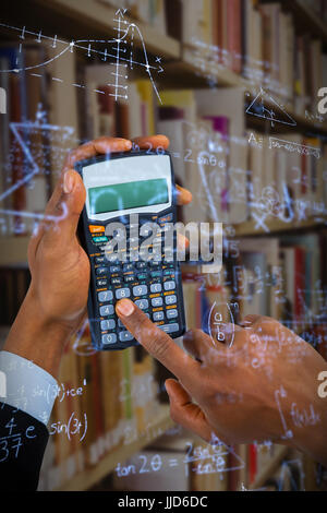 Händen der Geschäftsmann mit Rechner gegen Matheaufgaben gelöst auf Tafel Stockfoto