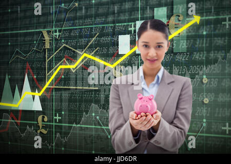 Porträt einer Geschäftsfrau hält ein Sparschwein gegen roten Pfeil Stockfoto