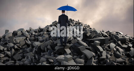 Rückansicht des Geschäftsmannes tragen blaue Regenschirm und Aktenkoffer gegen full-Frame-Schuss des Himmels Stockfoto