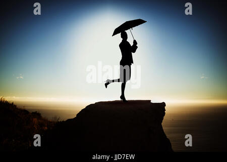 blaue Frau mit Regenschirm gegen die malerische Aussicht auf Berg Meer gegen Himmel Stockfoto