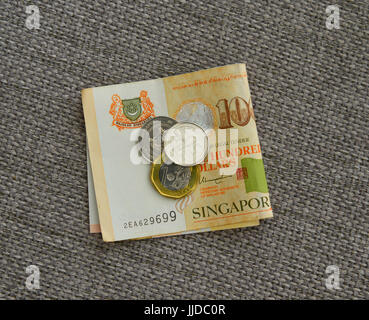 Singapur-Dollar-Münzen und Banknoten auf Leinenstoff. Hautnah. Geld-Konzept. Stockfoto